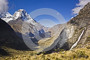 Sunrise above mountain Huascaran in Peru with waterfall