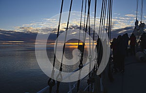 Sunrise at the arctic sea with a sail boat in front