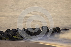 Sunrise on the beach. Beach with large stones and rocks. Ocean stones at the beach. Concept of calm, meditation, serenity.