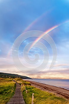 Sunrise at a beach with double rainbow