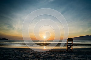 Sunrise on the beach with lifeguard stand photo