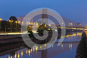 Beginning of the day in metropolis, bright lights and vehicles in transit. Sao Paulo city highway beside the river. photo