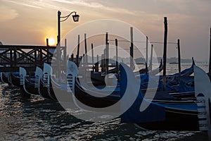 sunrise behind the pier with gondolas in Venice