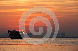 Sunrise behind the traditional fishing Dhow in the morning