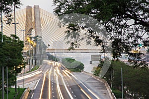 Sunrise, bright lights and vehicles in transit. Sao Paulo city highway beside the river. photo