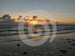 Sunrise the bright rays of the sun break through the clouds over the ocean. Cayo Coco, Cuba