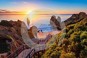 Sunrise at Camilo beach in Lagos, Algarve, Portugal. Wooden footbridge to the beach Praia do Camilo, Portugal. Picturesque view of