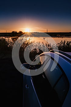 Sunrise. Car traveling image of lake sunrise or sunset reflection landscape