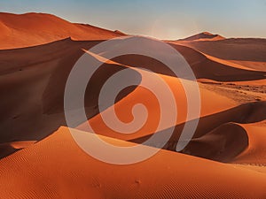 Sunrise casting shadows over the red sand dunes of the Namib Desert, Namibia.