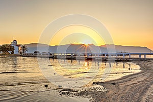 The sunrise at the church of Agios Spyridon in the port of Elafonisos, Greece