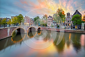 Sunrise colors in Amsterdam. Panoramic views of the famous old houses, the bridge and the canal in the downtown. Amsterdam,