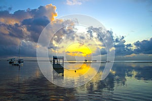 Sunrise with dramatic sky and boats