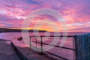 Sunrise at Filey fishing jetty looking towards Filey Brigg, Yorkshire, UK