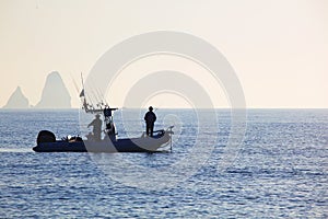 Sunrise with fishermen at sea photo