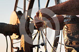 Sunrise on a fishing boat with a fishing net into the sea. Hands of the old fisherman holding a fishing net photo