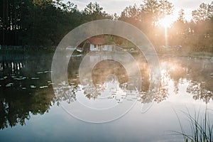 Sunrise. Fog, grass, trees against the backdrop of lakes and nature. Fishing background. Misty morning. nature. Wild areas. fence