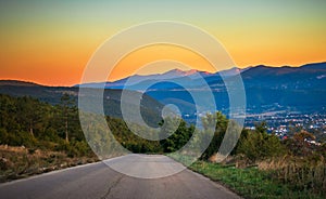 Sunrise with fog, mountains and town in the background