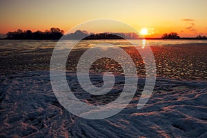 Sunrise and frozen river. Beautiful winter landscape with lake in morning time. Daybreak