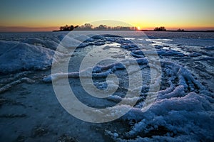 Sunrise and frozen river. Beautiful winter landscape with lake in morning time. Daybreak