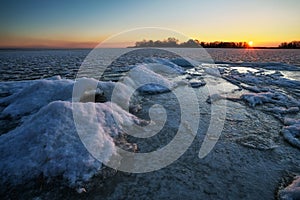 Sunrise and frozen river. Beautiful winter landscape with lake in morning time. Daybreak