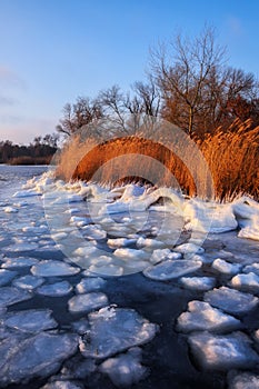 Sunrise and frozen sea. Beautiful winter landscape with lake in morning time