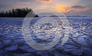 Sunrise and frozen sea. Beautiful winter landscape with lake in morning time