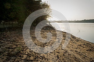 Sunrise, with golden sky and fog on the freshwater beach of the VÃ¡rzea das Flores dam.