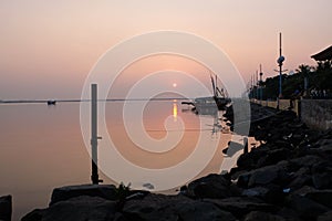 Sunrise in the harbor with a boat background on Ancol beach, Jakarta, Indonesia