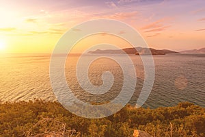 Sunrise on the island of Crete near Spinalonga with sea coast, rocks and dirt road