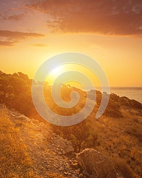 Sunrise on the island of Crete near Spinalonga with sea coast, rocks and dirt road