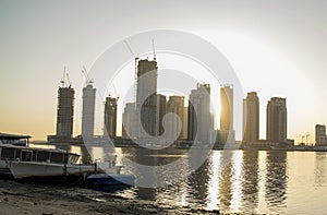 Sunrise in Jadaf area of Dubai, view of Dubai creek Harbor construction of which is partially completed. Old abandoned ships can