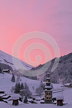 A sunrise at La CLusaz, in the French Alps, with the Church in the middle of the village