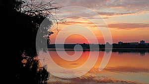 Sunrise on lake with clouds reflecting in water