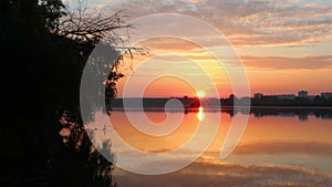 Sunrise on lake with clouds reflecting in water