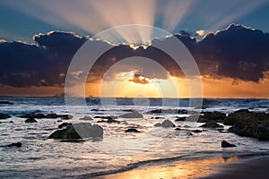 Sunrise landscape of ocean with waves clouds and rocks