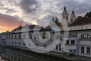 Sunrise landscape view of ancient city center of Ljubljana. Embankment of Ljubljanica River with colorful historic houses