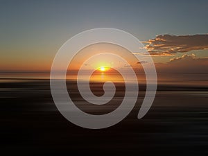 Sunrise light over the sea horizon background. Beautiful orange sunset sunrise on smooth wave water in the beach landscape.