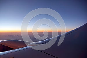 Sunrise light over the world full of clouds with Airplane Jet Wing