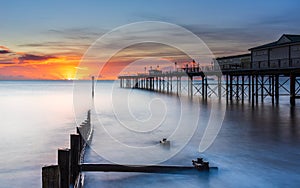 Sunrise in long time exposure of Grand Pier in Teignmouth in Devon