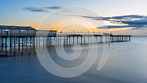 Sunrise in long time exposure of Grand Pier in Teignmouth in Devon