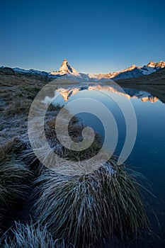 Sunrise on Matterhorn and its reflection in a mountain lake