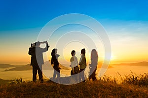 Sunrise on misty mountain with women and man