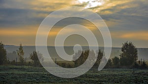 Sunrise and morning fog in autumn over a field