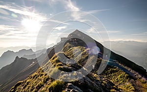 sunrise on the mountain peak with view to the mountain range of the swiss alps, sunflares mountain ridge