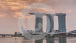 Sunrise near Marina Bay Sands Hotel dominates the skyline at Marina Bay in Singapore timelapse.
