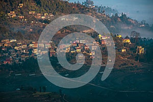 Sunrise in a Nepali Village. First rays of winter sun hitting the village settled on the slope of a hill. There`s a huge terrace