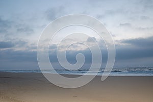 Sunrise on the ocean, white sky, and sand