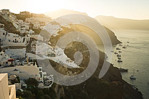 Sunrise in Oia village, Santorini island, Greece.  Boats in the harbour