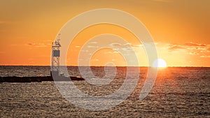 Sunrise over the Atlantic with a channel marker at the end of a jetty at Barnegat Inlet