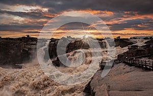 Sunrise over Augrabies falls in South Africa, Early morning, the light is golden yellow and orange.